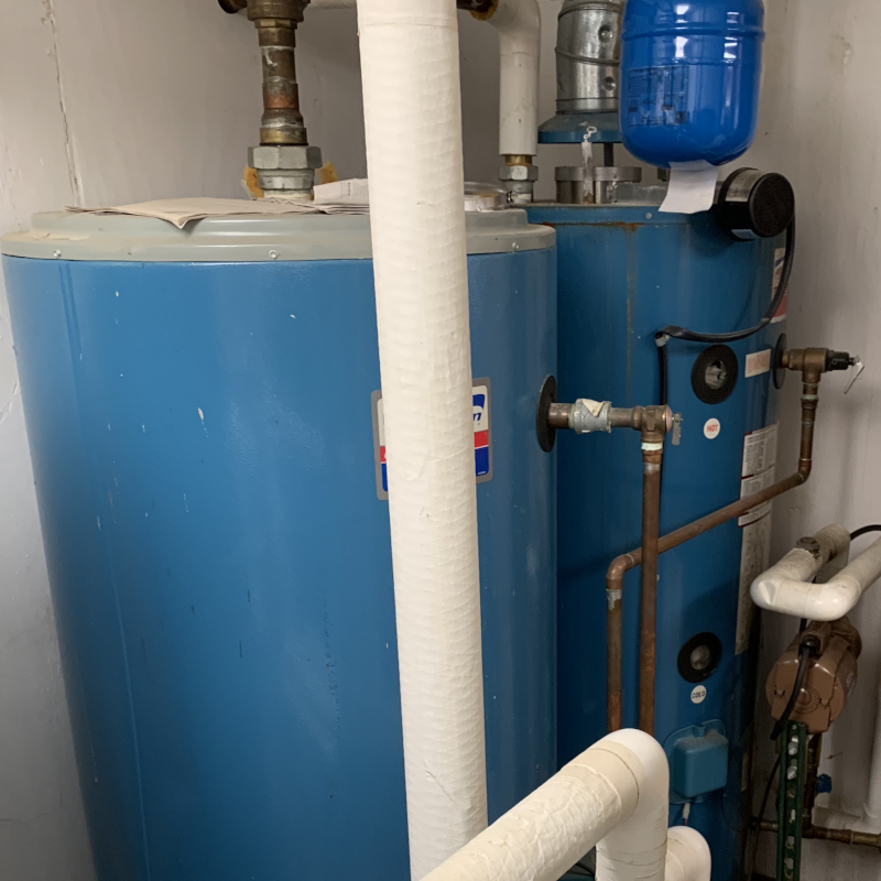 Residential water heater system with connected pipes and expansion tank.